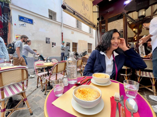 Niki at cafe looking off to the side smiling.