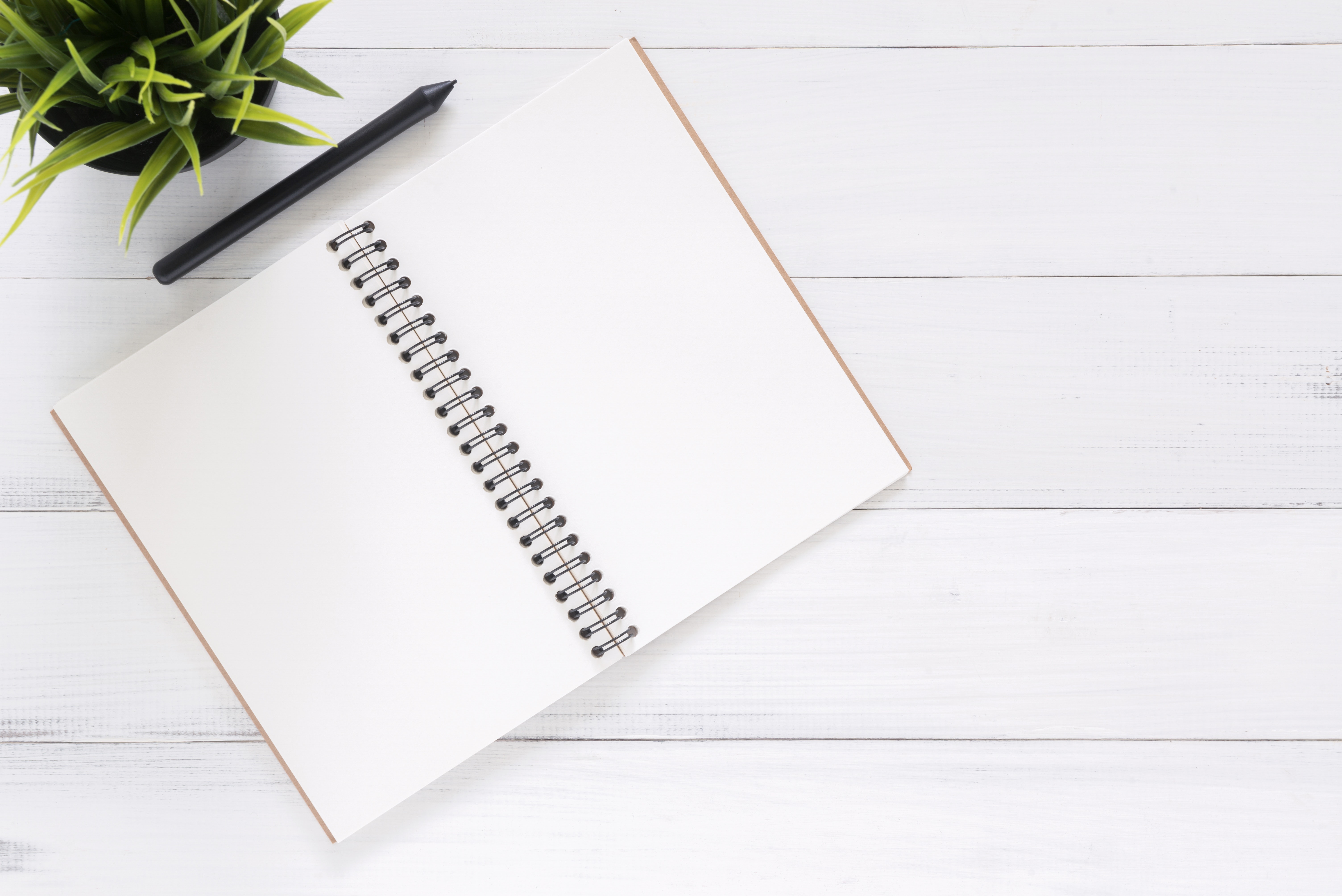 Open black notebook with pen on top ready to plan